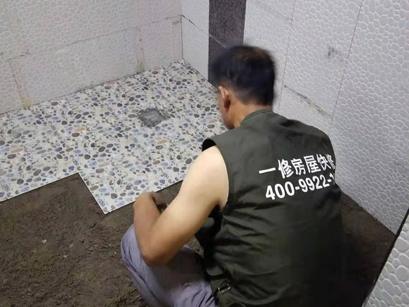 衛(wèi)生間地面花磚鋪貼:找平，就是在鋪仿古磚前，對(duì)鋪貼物表面進(jìn)行處理，如地面、內(nèi)墻面、外墻面等，消除表面附著的污物，并灑水進(jìn)行滋潤，然后用水泥沙混合找平，通常使用灰鏟在表面不停的涂抹使水泥地面保持大致水平，一定要等到水泥沙混合物完全干爽后再行鋪貼。用一段較長的細(xì)線，根據(jù)確定的鋪貼方式，在線上涂上顏色或白灰，然后在找平的地面上畫出仿古磚的位置及磚縫的參考線。 將亞光磚置入清水中浸泡，使瓷磚充分吸收水分，以不冒出氣泡為準(zhǔn)，防止干燥瓷磚在裝修完成后再次吸水而導(dǎo)致磚體變形。取出浸泡好的瓷磚，抹干水漬，在找平層上噴灑足夠的水，然后在磚背面均勻抹上水泥沙漿，沙漿厚度5~6cm為宜，鋪貼大規(guī)格亞光磚時(shí)適當(dāng)加厚；隨即將磚貼上，用木錘輕輕拍牢平整，避免空鼓，并隨時(shí)用直尺找平。