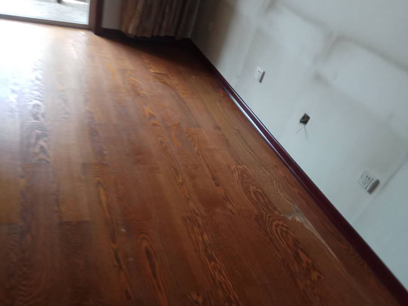 客廳木地板鋪貼：首先大家應(yīng)對(duì)是施工地進(jìn)行清理，把無(wú)關(guān)的東西都移出去，并且把地面上的垃圾清掃干凈，包括每一個(gè)角落。然后對(duì)地面進(jìn)行找平，水平誤差不能超過(guò)2mm，超過(guò)的話就要想辦法找平了。地面要是不平，地板鋪好后腳感當(dāng)然也就不好了。 木地板遇潮后易起拱、變形,為了避免這種情況,大家需要對(duì)地面進(jìn)行防潮處理。常見的處理方法是在地面上鋪防潮層，這樣可以防止以后地板受潮。防潮層要鋪平，接縫處要并攏。 為了讓地板鋪出來(lái)的效果更加的美觀，大家最好先預(yù)鋪下，將部分地板一分為二，要根據(jù)尺寸來(lái)鋸，萬(wàn)一鋸多了，地板損耗就大了。在鋸地板前可以將地板全部打開包，挑出有問(wèn)題或瑕疵的地板來(lái)鋸，這樣可以有效將局部有問(wèn)題的地板充分利用，不產(chǎn)生過(guò)大損耗。千萬(wàn)不要上來(lái)就拿好地板來(lái)鋸，那會(huì)增加損耗的。鋸地板的地點(diǎn)務(wù)必要選在陽(yáng)臺(tái)等有瓷磚好打理衛(wèi)生的地方，否則飛濺的木灰會(huì)無(wú)孔不入的進(jìn)入任何地方，很難清潔。