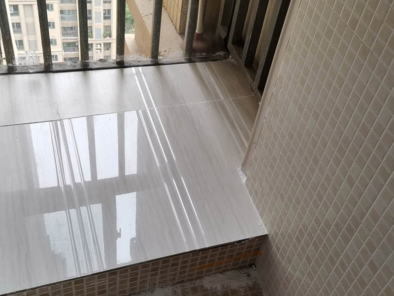 陽臺(tái)瓷磚鋪貼：準(zhǔn)備粘結(jié)劑前，瓷磚不應(yīng)浸水，但要用鋼絲刷除去磚背面的松散物質(zhì)，并用濕布抹去磚背的浮塵。然后按照生產(chǎn)商建議的比例將水或乳液放到攪拌桶中攪拌直至粘結(jié)劑均勻無結(jié)塊。初始攪拌后的粘結(jié)劑應(yīng)靜置在攪拌桶中，直到生產(chǎn)商推薦的熟化時(shí)間過后攪拌一下再使用。 在鋪壓瓷磚前，在瓷磚背面也批一薄層粘結(jié)劑。這種雙批法雖然用的材料和工時(shí)比較多，但卻能夠保證粘貼的質(zhì)量和耐久性。 在粘結(jié)劑量置晾時(shí)間內(nèi)，將準(zhǔn)備好的瓷磚鋪壓到位，垂直于梳理方向輕微搓動(dòng)以排出磚下的空氣。鋪貼到位后用橡皮錘輕擊，用尺寸合適的十字定位架來調(diào)整表面平整度及接縫的平直。