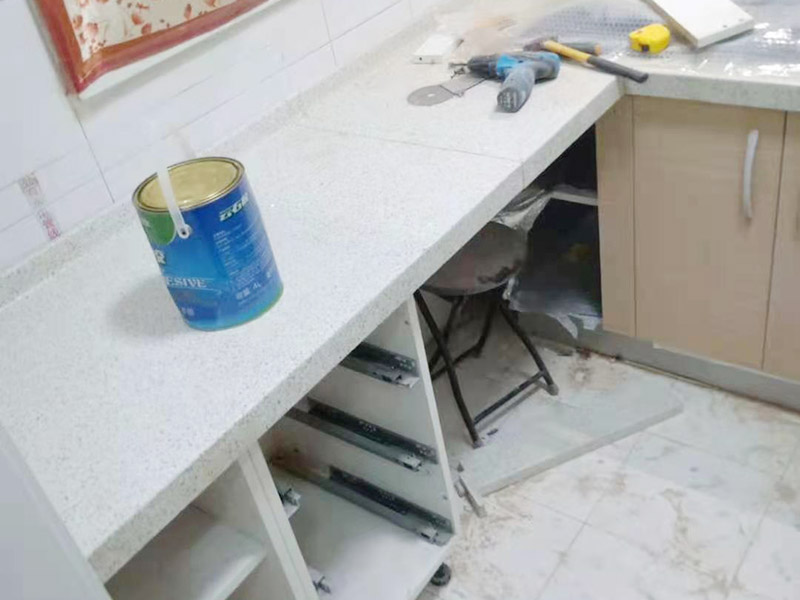 櫥柜維修改造：對廚房作防護措施,掛擋布、廚房墻面等做簡單清理,以便準確測量地面水平。 材料進場:櫥柜板材等進場。  安裝地柜 組裝:統(tǒng)一組裝好地柜,搬進廚房,按圖紙順序擺放好位置(倒放),統(tǒng)一安裝地腳。 現(xiàn)場切割:地面上墊上保護物,割口根據(jù)實物的大小從反面進行操作,保持正面不崩。 安裝順序：如有轉(zhuǎn)角柜應先安轉(zhuǎn)角柜，沒有轉(zhuǎn)角柜先從靠墻的柜往外安裝。 水平調(diào)整：通過地柜的調(diào)節(jié)腿調(diào)節(jié)地柜水平度，誤差保持正負1mm。