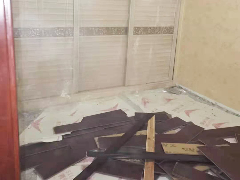 地板拆除施工：再把房間的物品都搬到另一房間去放著，把整個房間騰出來，這樣也更好的尋找木地板的縫隙源頭，沒有東西擋著，空曠也利用木地板的拆除。拆除的工作要先從踢腳線開始，就算是發現木地板中間有縫隙，或者有損壞的地方，感覺可以下手拆除，實際操作時，還是從踢腳線要好拆些。踢腳線一般分為兩種，若是很幸運碰上了卡子固定的踢腳線，那就容易多了。直接用工具把卡子撬松，卡子脫落后，就可以沿著踢腳線開始拆了。若是碰上的是打了膠的踢腳線，那么就有點難度。先用刀片把膠水刮掉，但是這樣容易傷到地板。