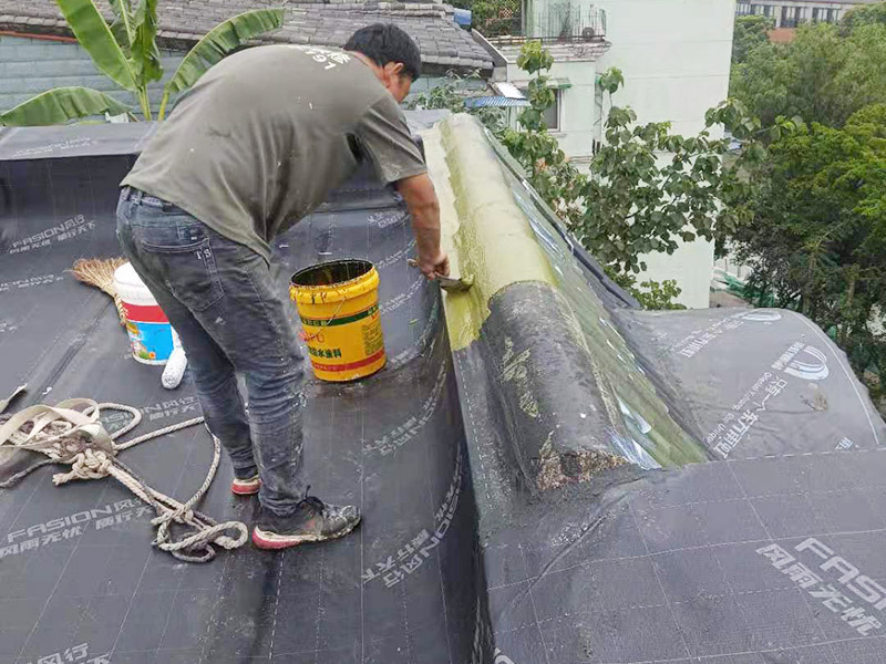屋面防水卷材后刷防水：防水層鋪貼之前，所有其它工程必須施工完畢，然后清理基層。基層必須平整、堅固、無松動、起砂、起鼓、 凹凸和裂縫，而且防水一般都是兩遍，最好是卷材防水和涂料防水一起做，這樣最保險，在基層先均勻涂刷基層處理劑一層。待基層處理劑干燥后,可涂刷膠粘劑，應一次涂刷均勻。將卷材按預定位置放好后開始鋪貼，用膠粘劑粘平，干燥數分鐘后用壓輥壓實。